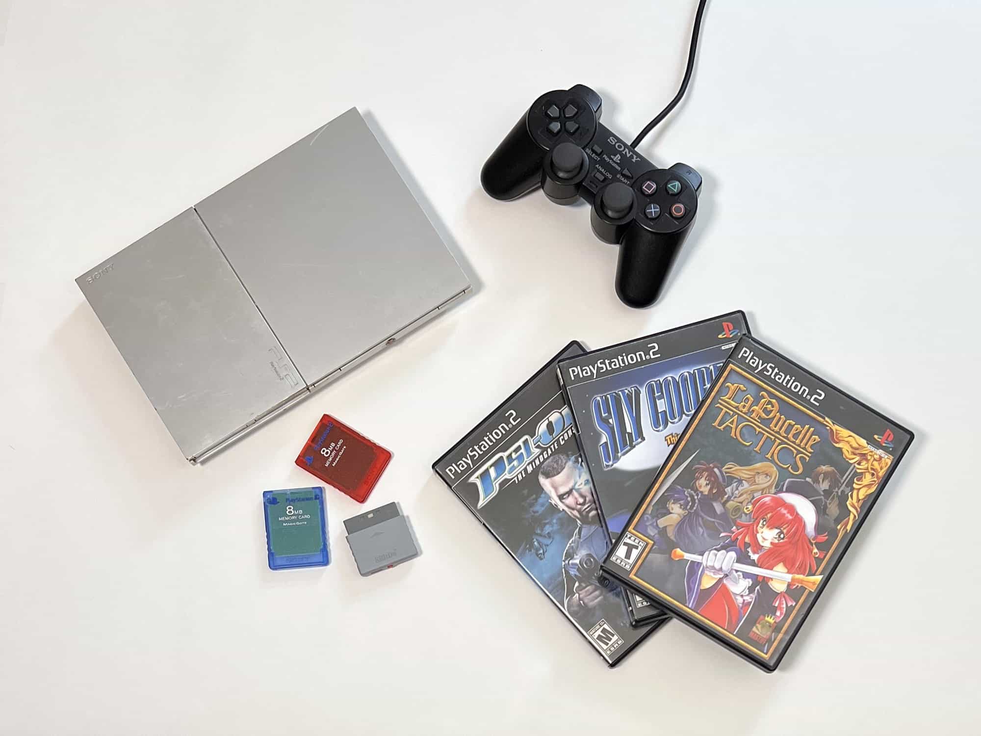 PS2 beginner's guide starter kit: silver slim PS2, DualShock 2 controller, memory cards, and three PS2 games